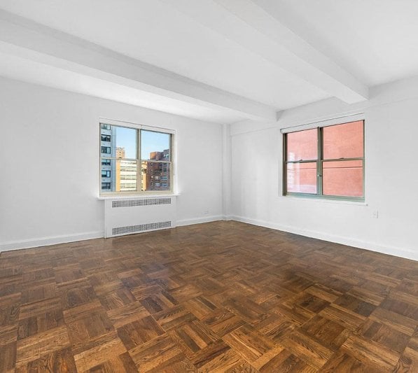 a white room in an apartment with wood floors