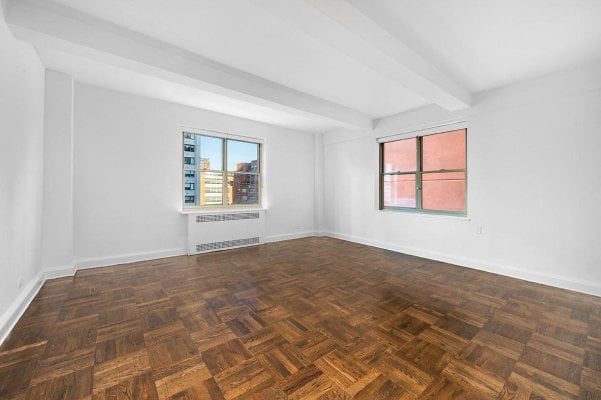 a white room in an apartment with wood floors