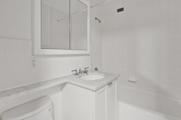 a clean white bathroom in an NYC apartment rental