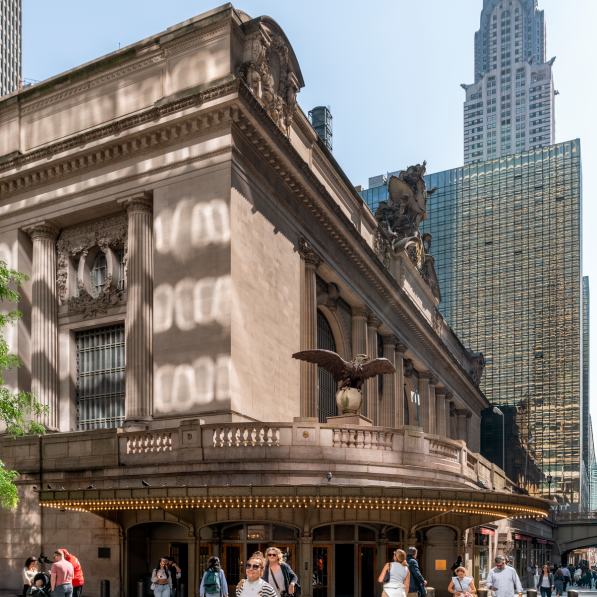 people walking past a large building