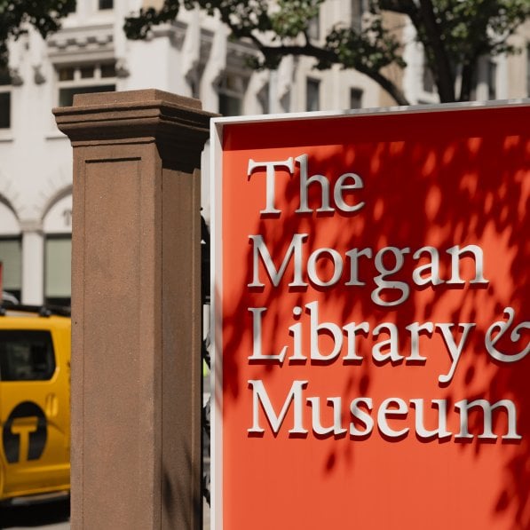 A red sign for The Morgan Library & Museum with the building in the background