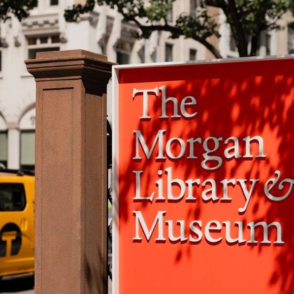 Signage for The Morgan Library & Museum with the building in the background