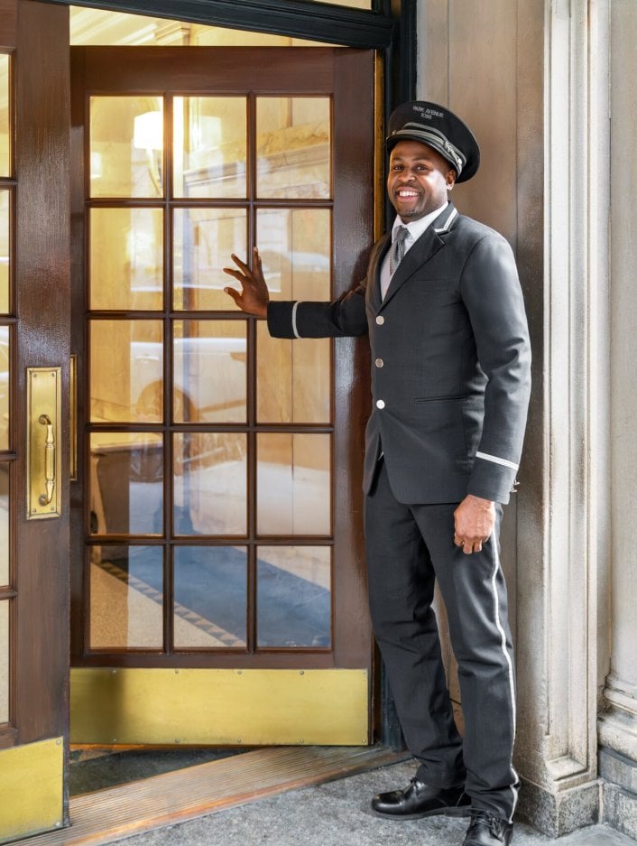A doorman holding open a door