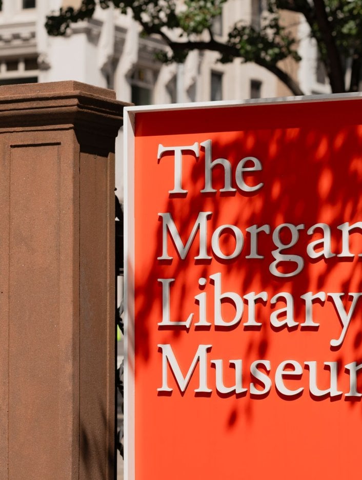 Signage for The Morgan Library & Museum with the building in the background