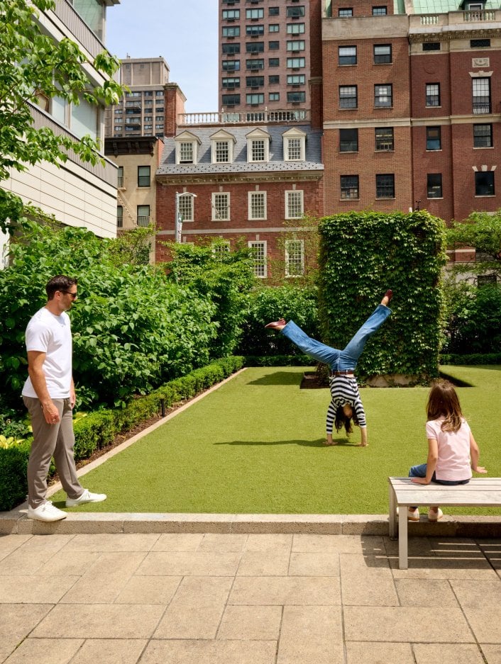 A family plays in a park during summer on the Upper East Side of NYC 